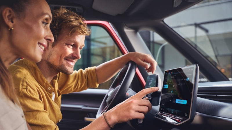 Paar nutzt In-Car App Fahrzeugservice im VW Infotainment-System.