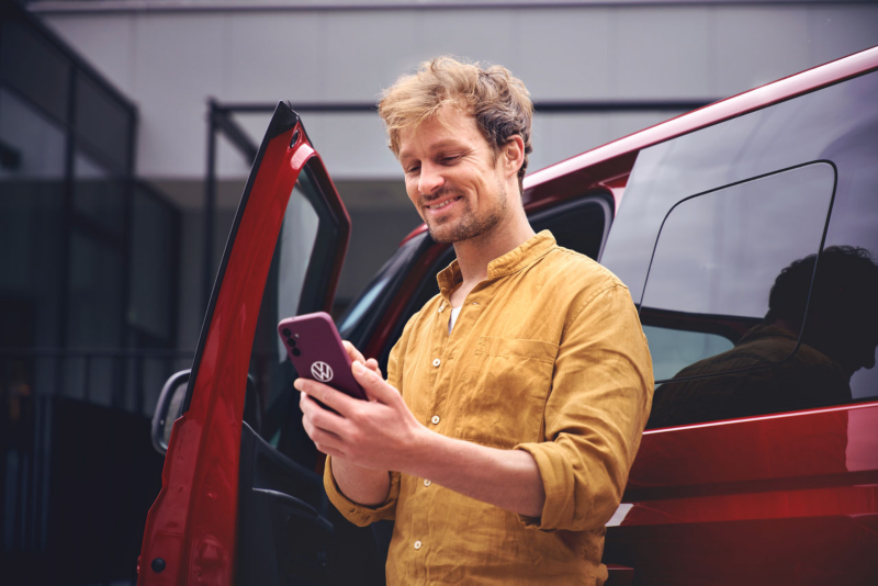 Dos chicas sentadas en el asiento trasero mirando algo en un smartphone conectado.