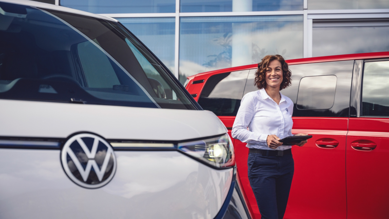 VW Service Mitarbeiterin zwischen ID. Buzz Modellen.