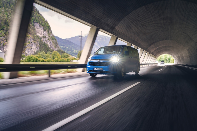 El VW Nuevo California aparcado en la orilla junto a dos personas.