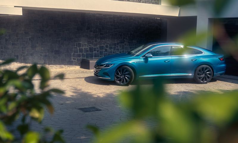 A blue Arteon parked on a driveway