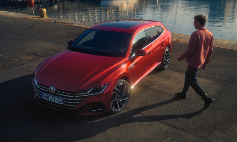 En mand er på vej ind i en rød arteon shooting brake