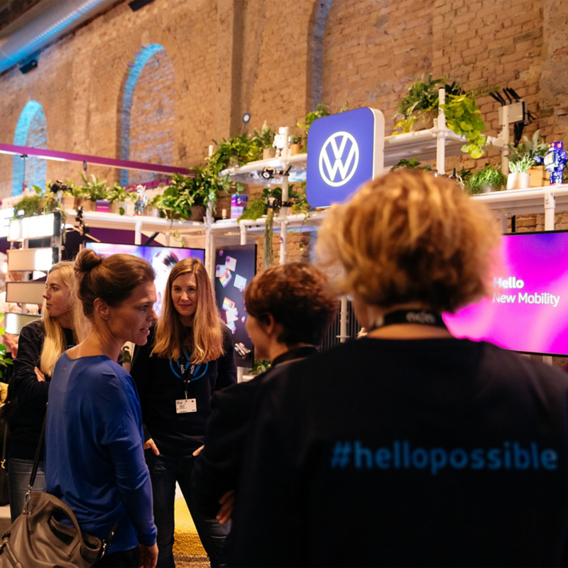 Menschen auf einer Messe-Veranstaltung vor einem Volkswagen Stand