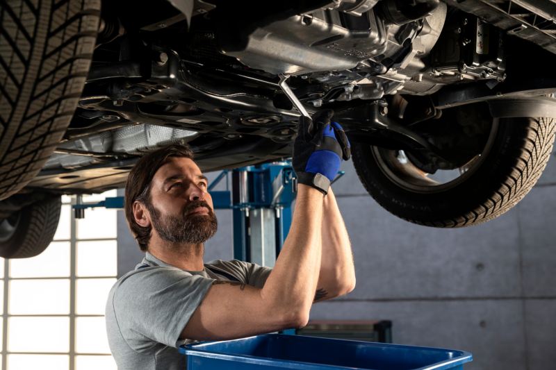 Man working under car, changing oil