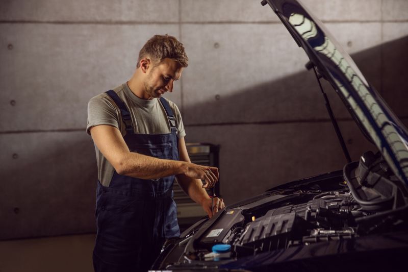 A VW service employee measures the tyre tread depth on a VW vehicle