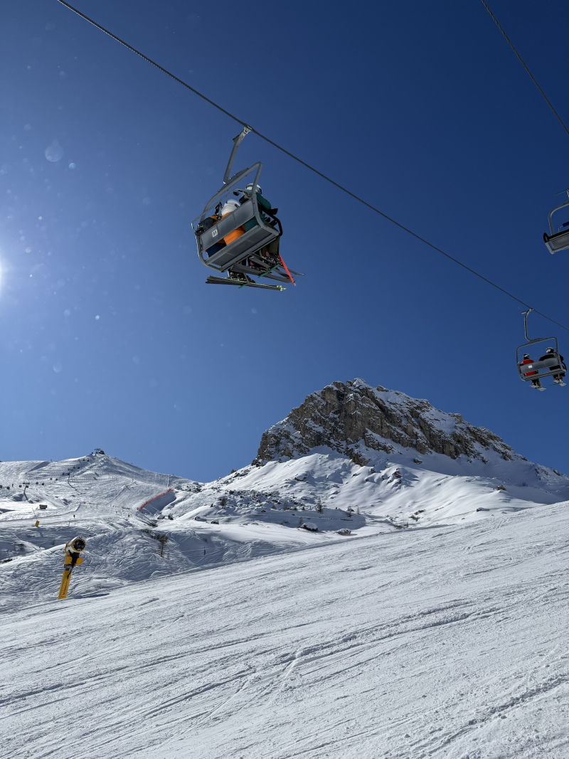 Sittlift som åker över snöklädda skidbackar i Alperna