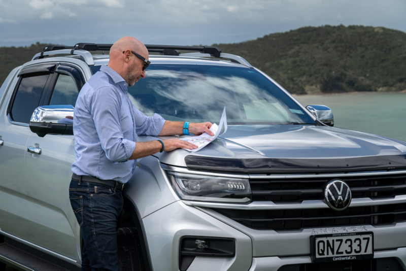 Man looking at sheet on Amarok hood 
