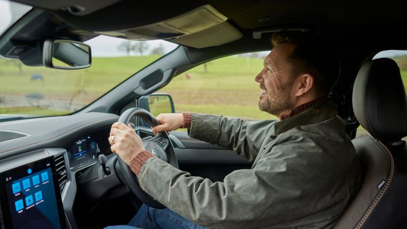 The interior of a VW Amarok showing a man driving. 