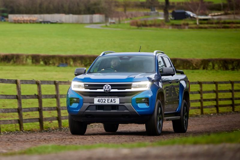 A VW Amarok driving down a country road. 