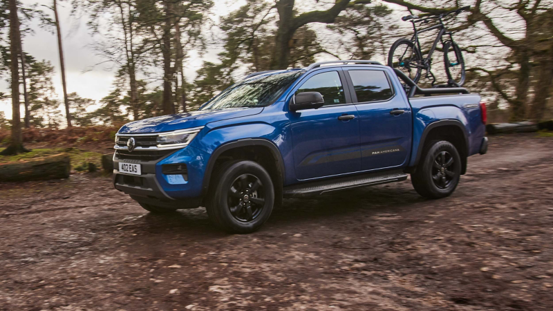 A VW Amarok driving against a countryside backdrop.