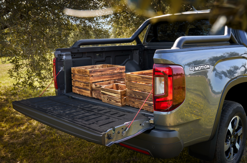 Trabajadores forestales de pie junto al compartimento de carga del VW Amarok.