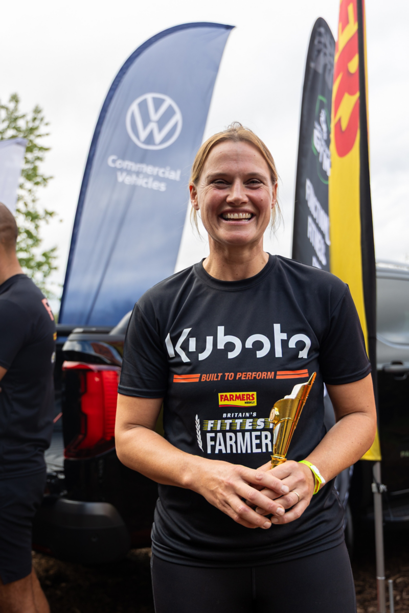 a woman smiling and holding a trophy
