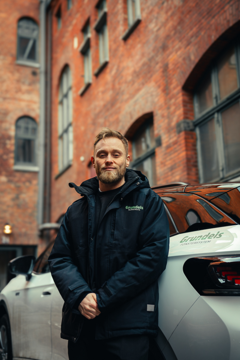 Anton Thölén lutar sig mot bakdelen på en vit Volkswagen ID.4.