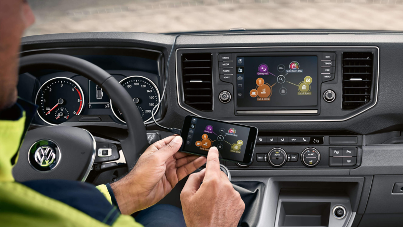 Bestuurder gebruikt navigatiesysteem door middel van zijn smartphone
