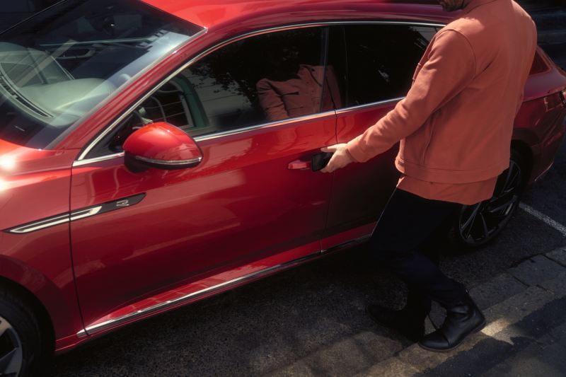 Un uomo apre la portiera di una Volkswagen Arteon per uso aziendale.