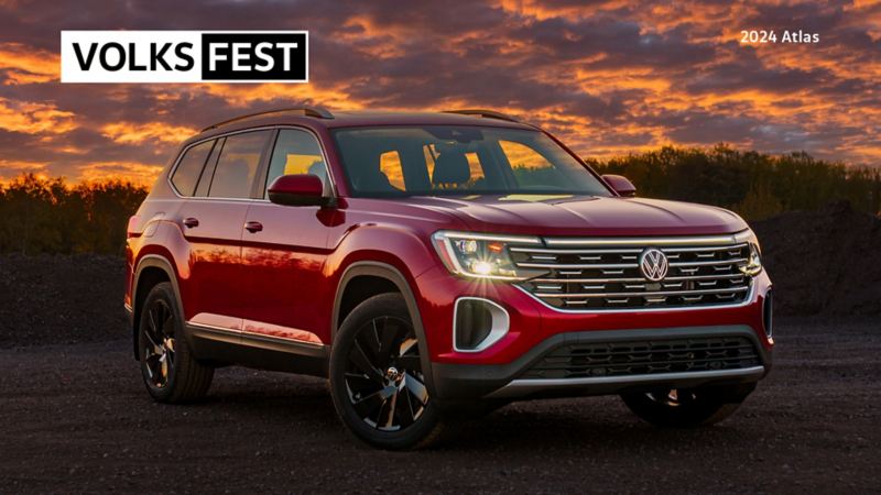 A red Volkswagen Atlas in front of a sunset.