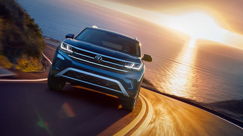 The 7-seat All-Wheel Drive 2023 Volkswagen Atlas driving down the serpentine road at the sunset