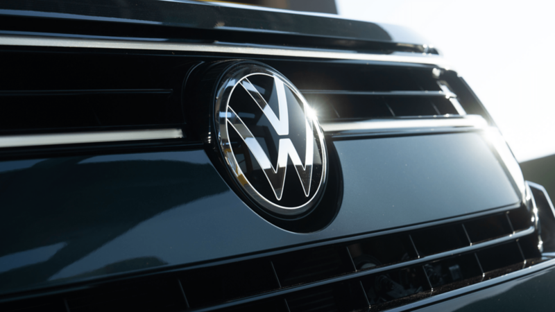 Gros plan du logo Volkswagen chromé sur la calandre avant.