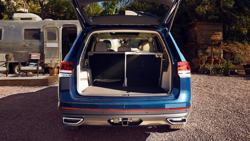 A spacious trunk of the blue 2023 Volkswagen Atlas parked in a park.