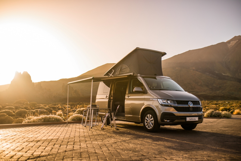 Image of a California 6.1 with the pop-up roof and awning open.