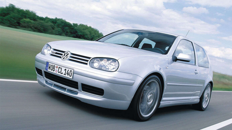 a low angle view of a silver Golf GTI driving along a tree-lined road