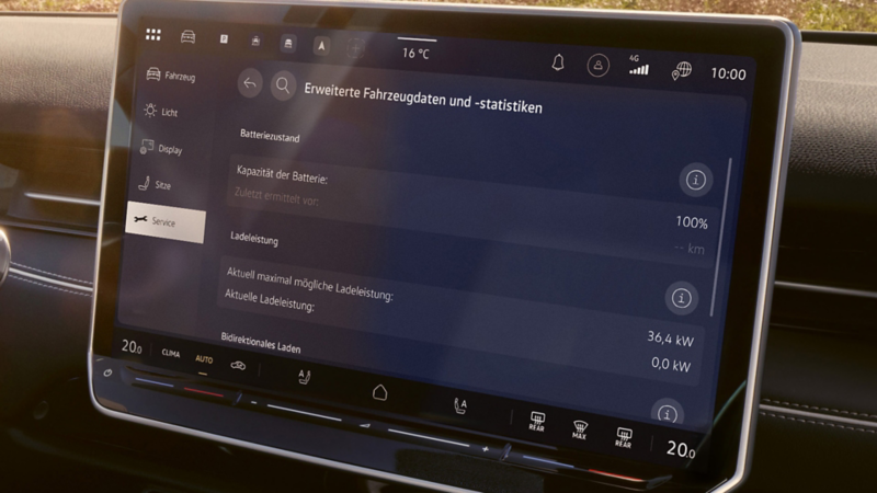 Ein Mann sitzt auf dem Fahrersitz eines VW Elektrofahrzeuges und bedient das Infotainmentsystem.