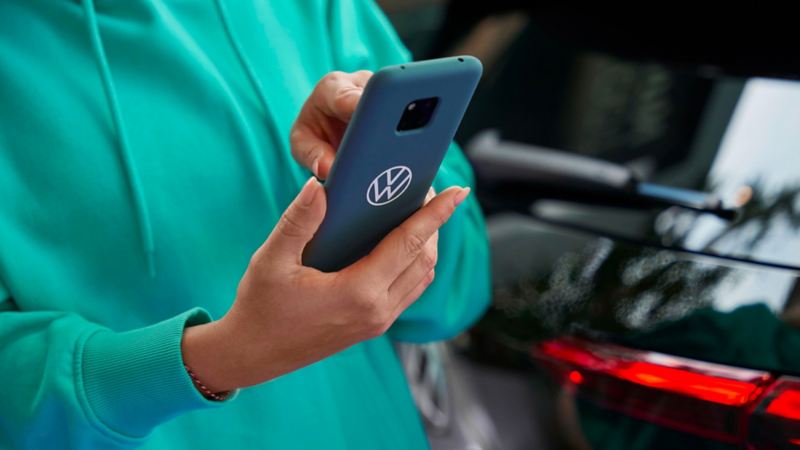 Woman checks EU declarations of conformity of VW portable batteries on the smartphone