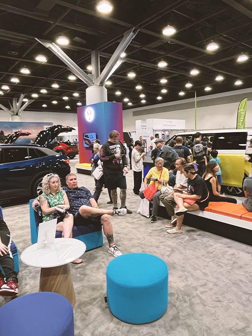 A group of Fully Charged attendees lounging around the Volkswagen booth