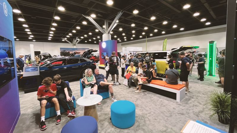 A group of Fully Charged attendees lounging around the Volkswagen booth