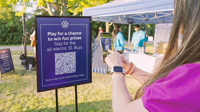 A festival attendee scanning a Volkswagen QR code