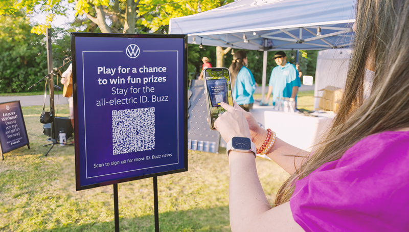 Une festivalière balaie un code QR de Volkswagen