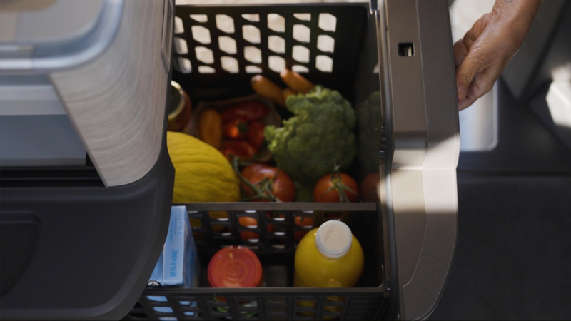 Nahaufnahme eines Kühlschranks, gefüllt mit Getränken, frischem Obst und Gemüse.
