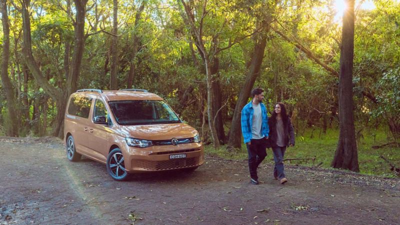 Volkswagen Caddy California driving on dirt road. 