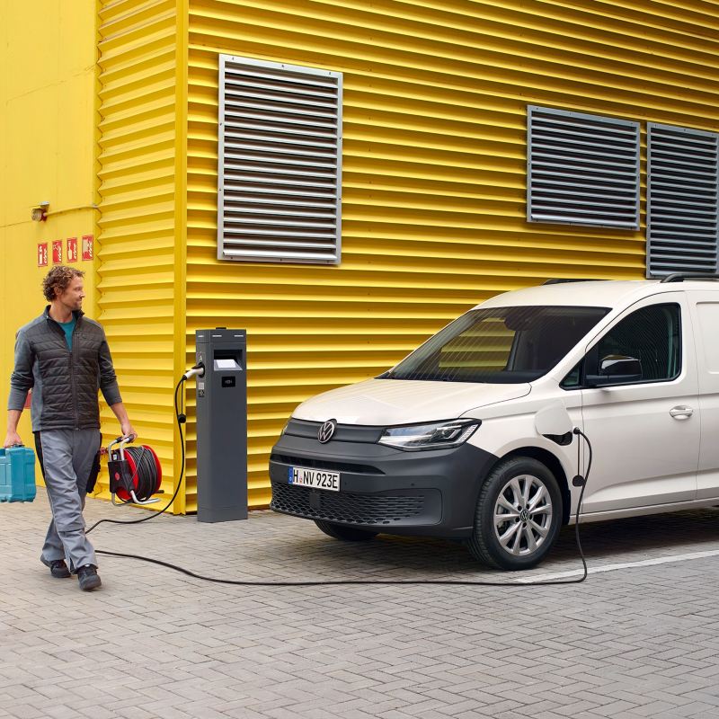 VW Caddy Cargo skåpbil som laddhybrid laddar vid laddstation