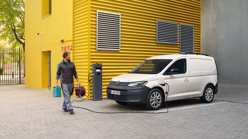 Ein VW Caddy Cargo eHybrid steht an einer Ladestation.