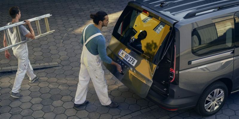 Due pittori caricano Volkswagen Caddy Kombi.