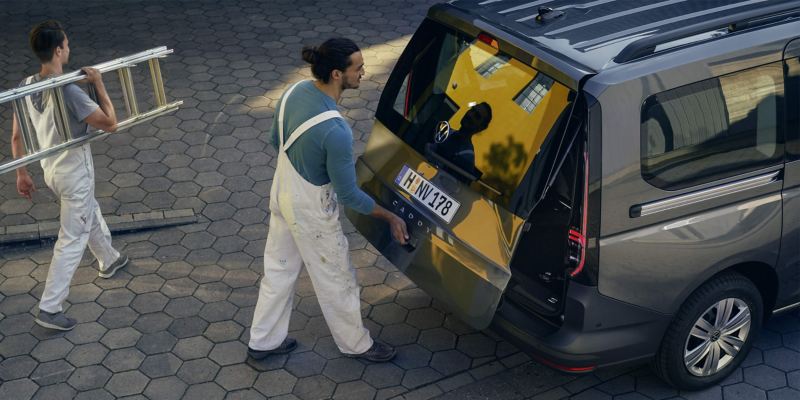 Deux peintres chargent le VW Caddy Combi.
