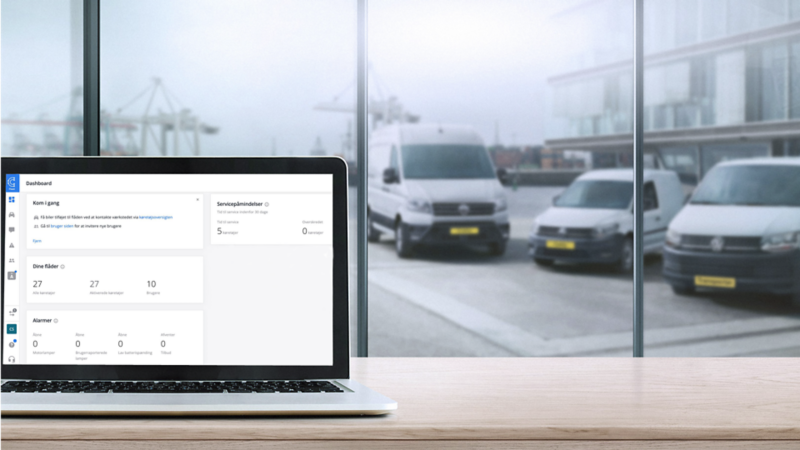 En åben computerskærm med parkerede varevogne i baggrunden