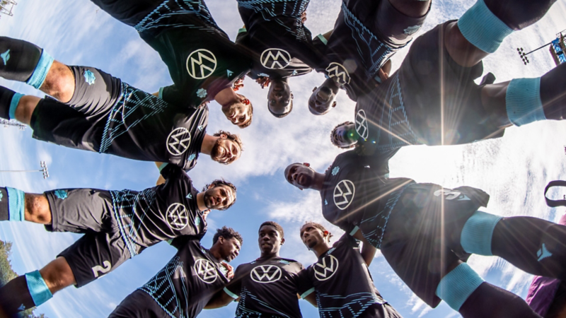 Soccer players wearing a blue jersey with the Volkswagen logo on it.