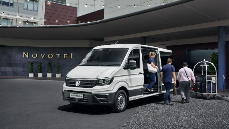 Customers outside the Novotel hotel stepping out of VW shuttle van