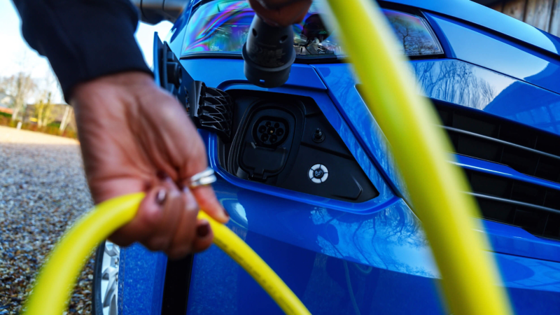 close up of a plug-in hybrid van being plugged in to charge