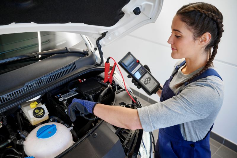 Un employé de Volkswagen vérifie la batterie d'un véhicule Volkswagen
