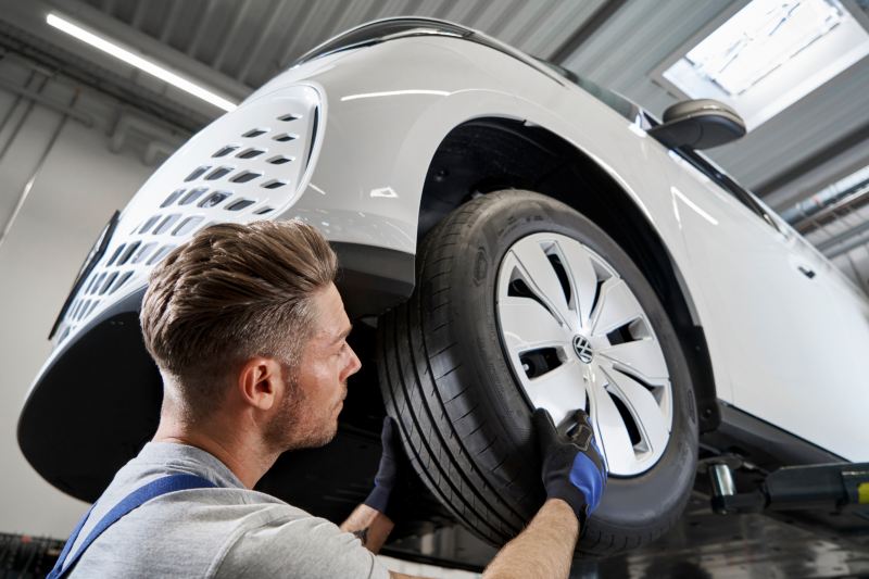 Un employé de Volkswagen travaille sur les pneus d'un véhicule Volkswagen