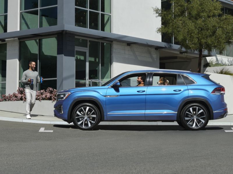 L’Atlas Cross Sport 2024 de Volkswagen bleu Kingfisher métallique garé près d’une maison sur la rue.