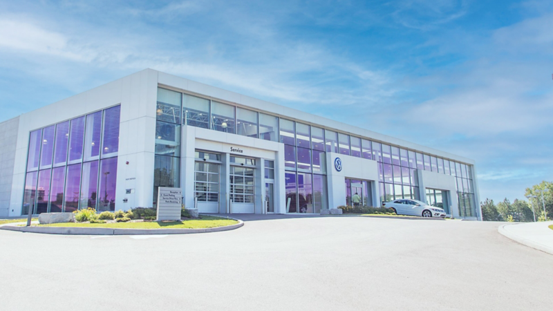 A Volkswagen dealership building on the sunny day