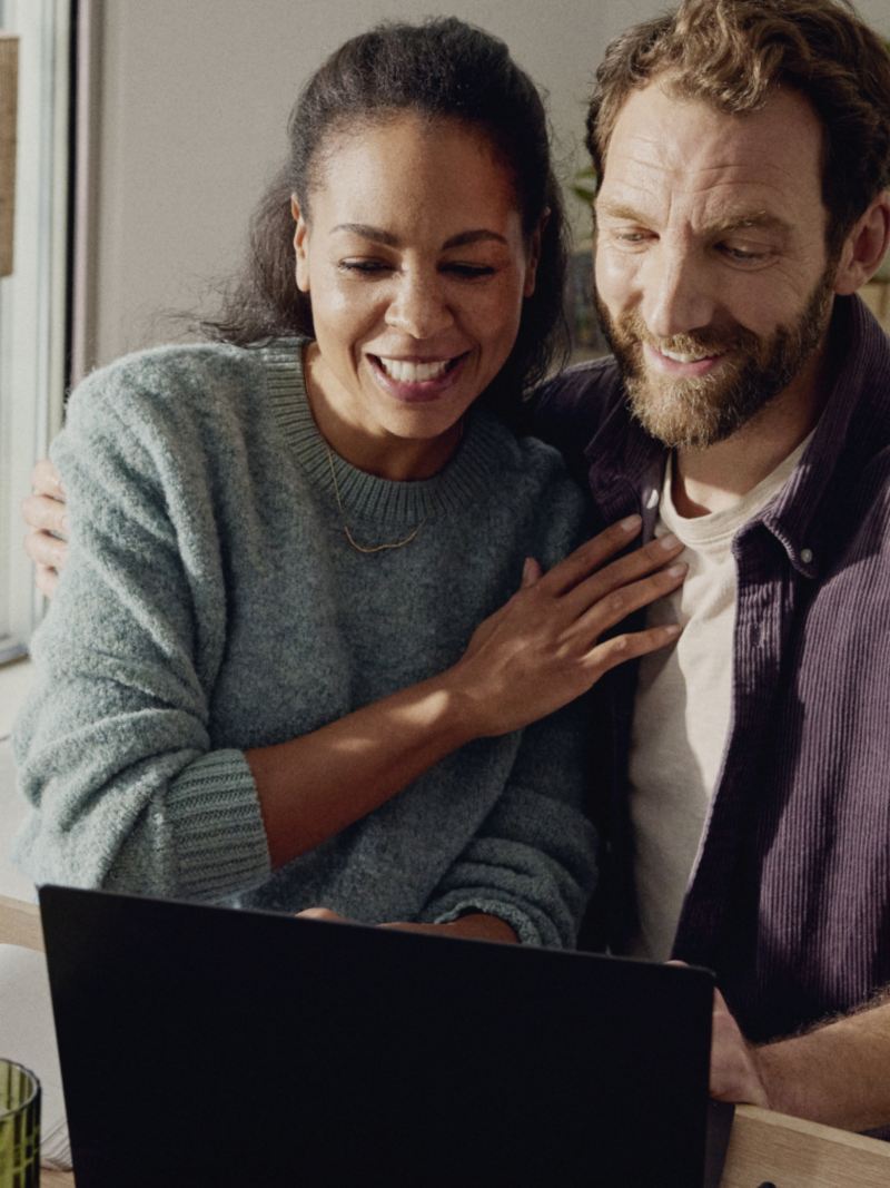 Un homme et une femme regardent un écran d’ordinateur portable à la maison