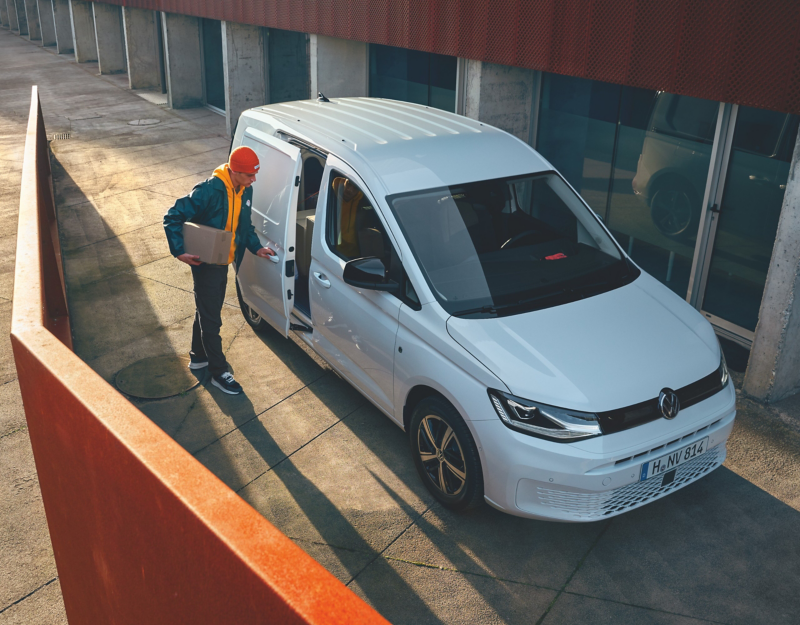 Worker with the Volkswagen Caddy Cargo parked beside office.