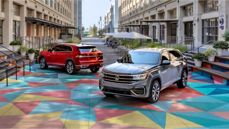 VW Atlas y Atlas Cross Sport estacionados sobre pavimento pintado con motivos geométricos.
