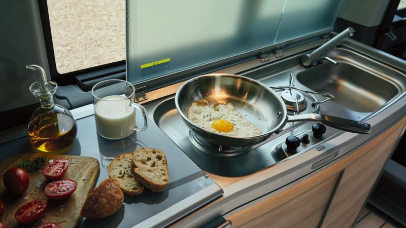 Young girl playing with family in VW California kitchen