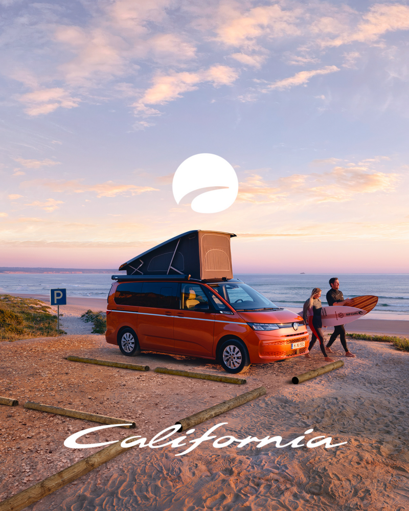 un california orange garé avec toit ouvert et deux surfeurs, planches en main